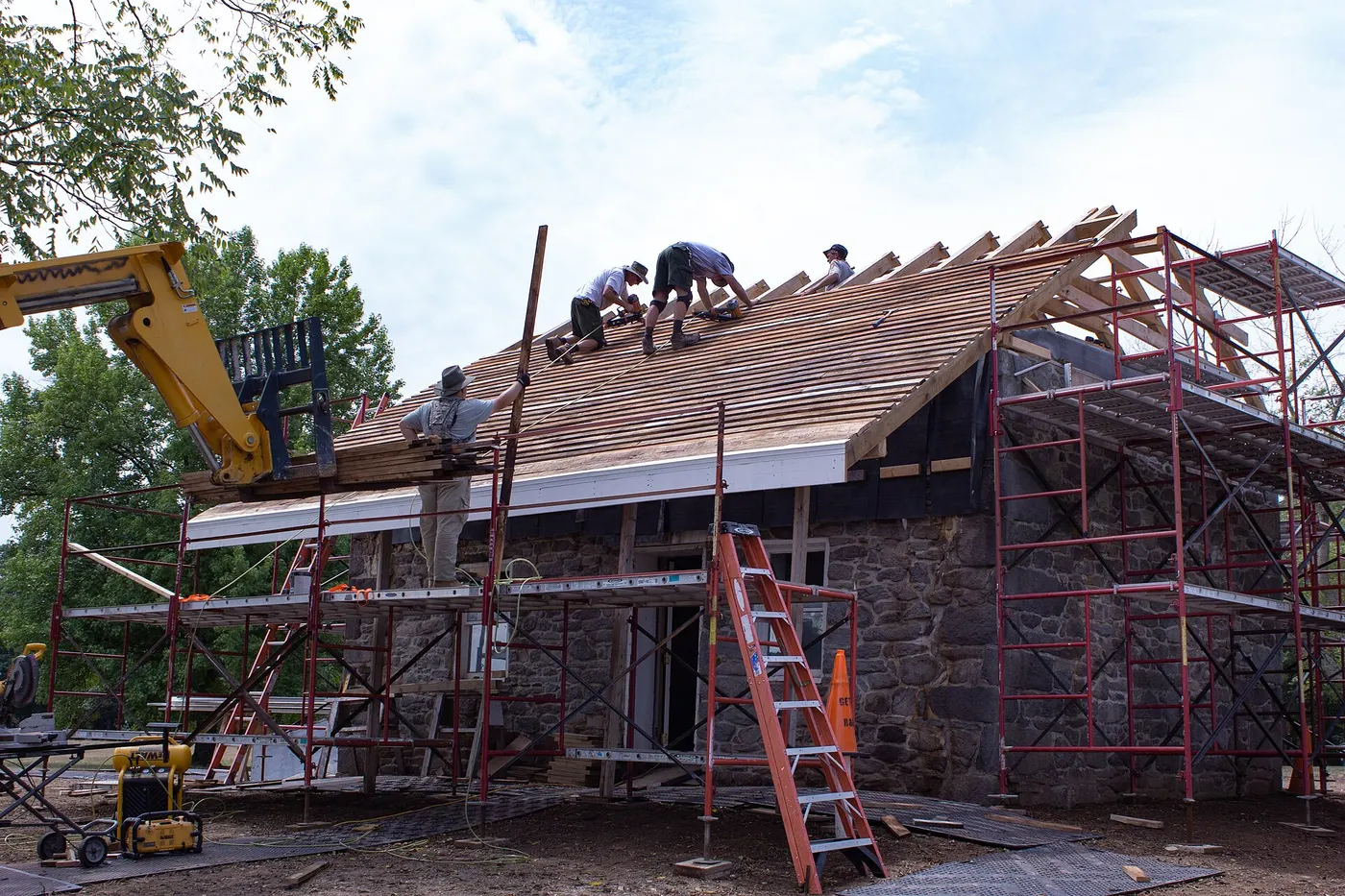 Crew installing new shingles during a roof replacement